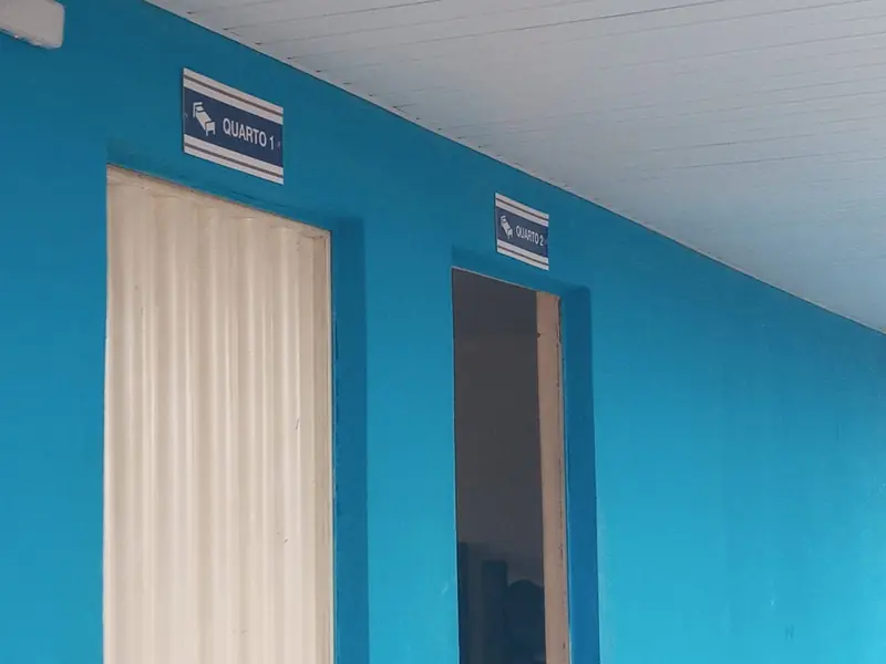 Corredor com paredes azuis e portas dos quartos numerados